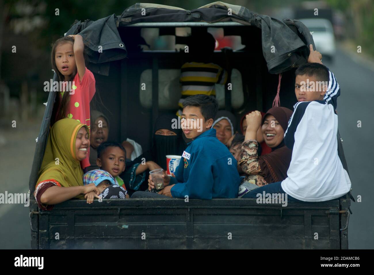 Indonesier, die auf der Rückseite eines Pickup-Trucks unterwegs sind, Lombok, Indonesien Stockfoto