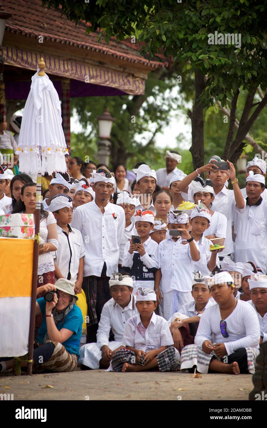 Balinesische Templegoers im Sakenan Tempel, Bali, Indonesien, beobachten Tempeltanz Zeremonie. Stockfoto