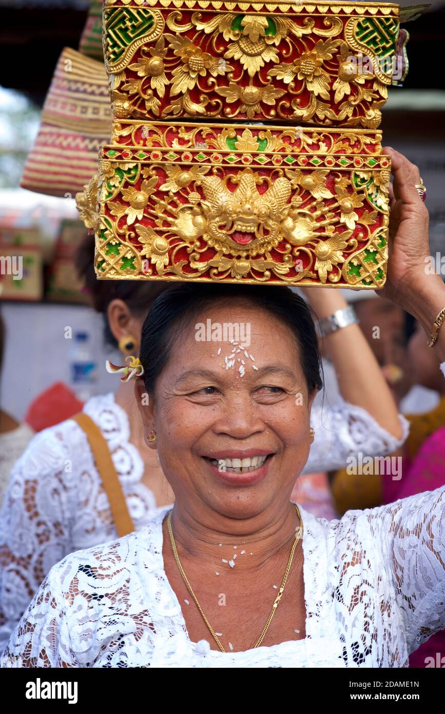 Balinesische Frau in zeremonieller Kleidung mit Opfergabe in einem traditionellen Korb, Sakenan-Tempel, Bali, Indonesien Stockfoto