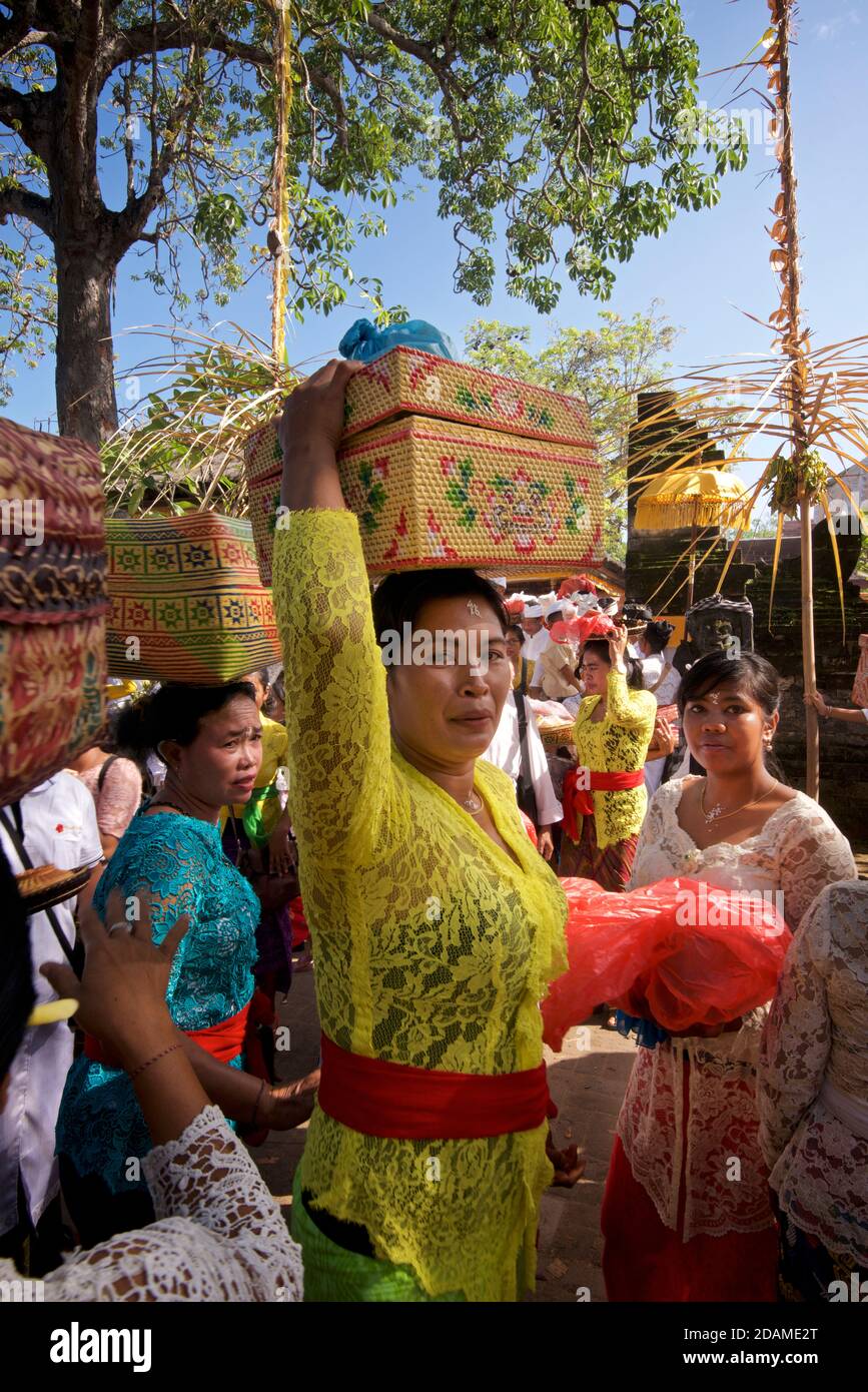 Balinesische Tempegoer besuchen Sakenan Tempel für Galungganfeiern, Bali, Indonesien. Frau, die einen Korb mit Opfergaben trägt Stockfoto