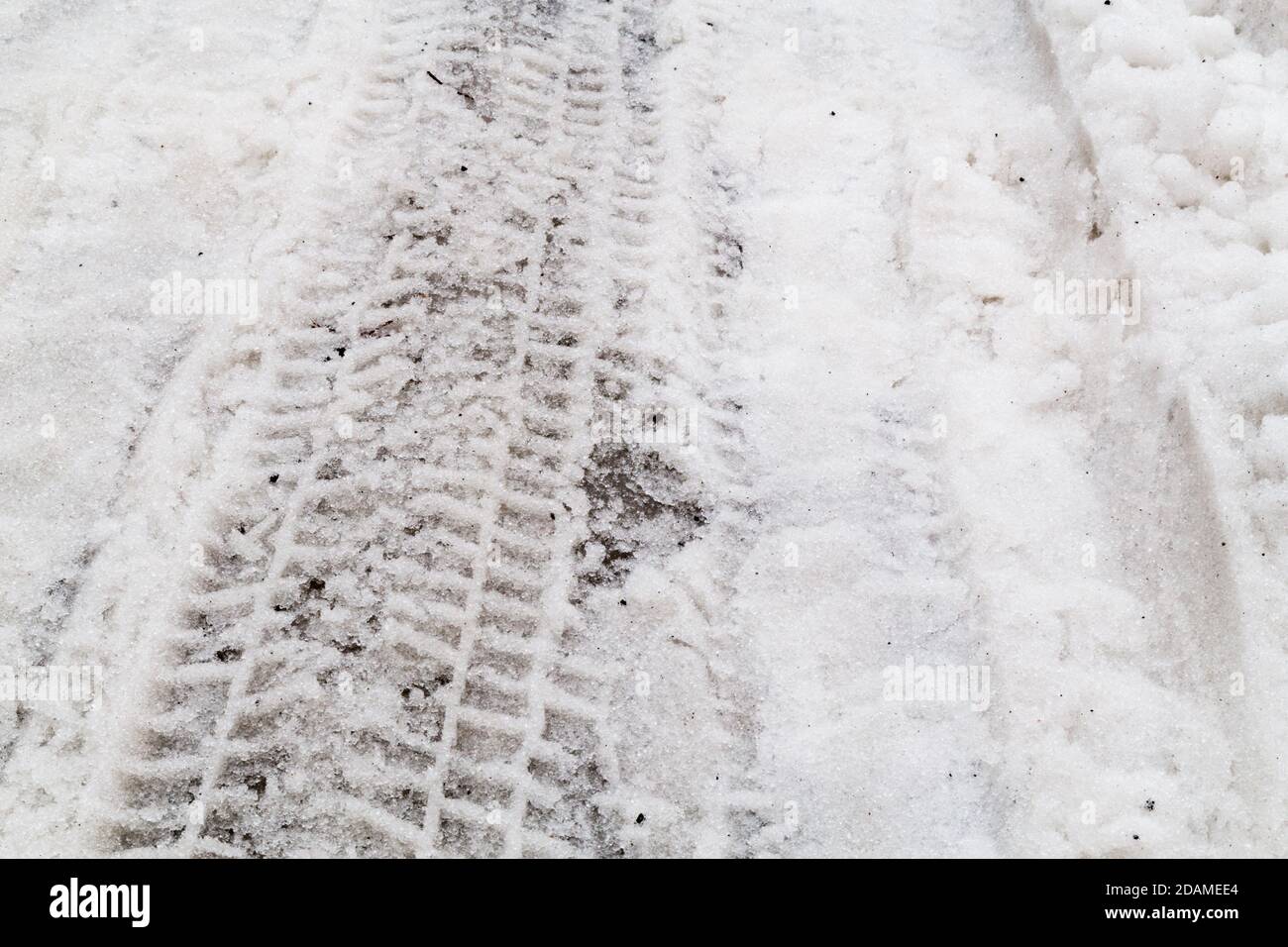 Nahaufnahme auf Reifenpistenabdruck auf schneebedeckten Straßen Stockfoto