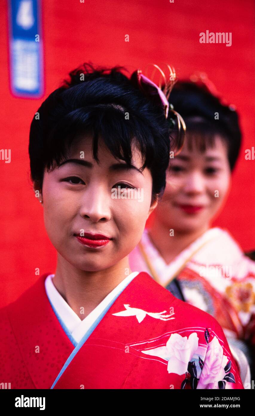 Zwei japanische Frauen in zeremoniellem Kleid Kimonos treffen sich auf einer Straße in Tokio, Japan. Stockfoto