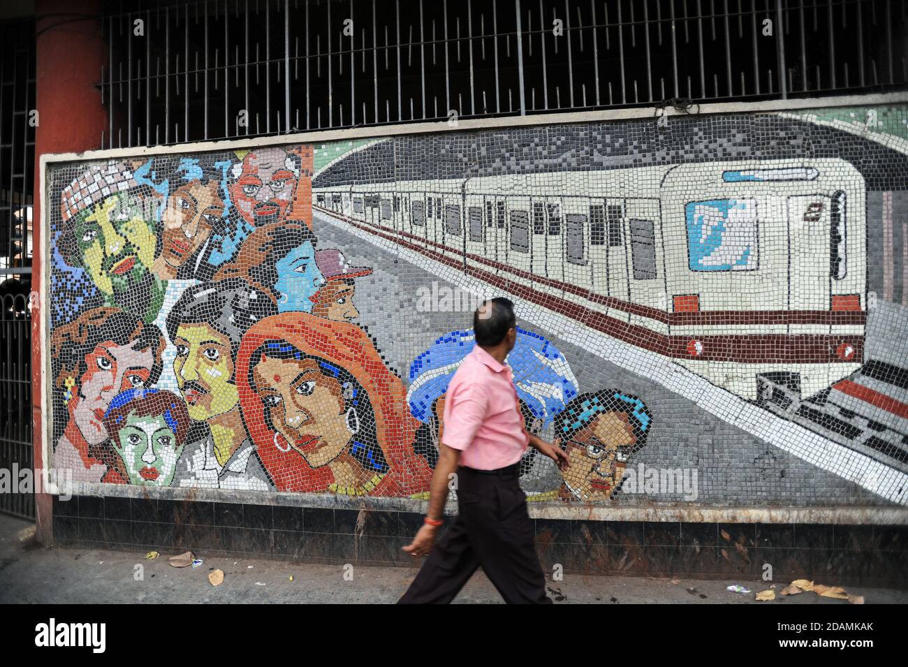 21.02.2011, Kolkata (Kalkutta), Westbengalen, Indien, Asien - EIN Mann geht an einem bunten Kachelmosaik vor einer U-Bahn-Station vorbei. Stockfoto