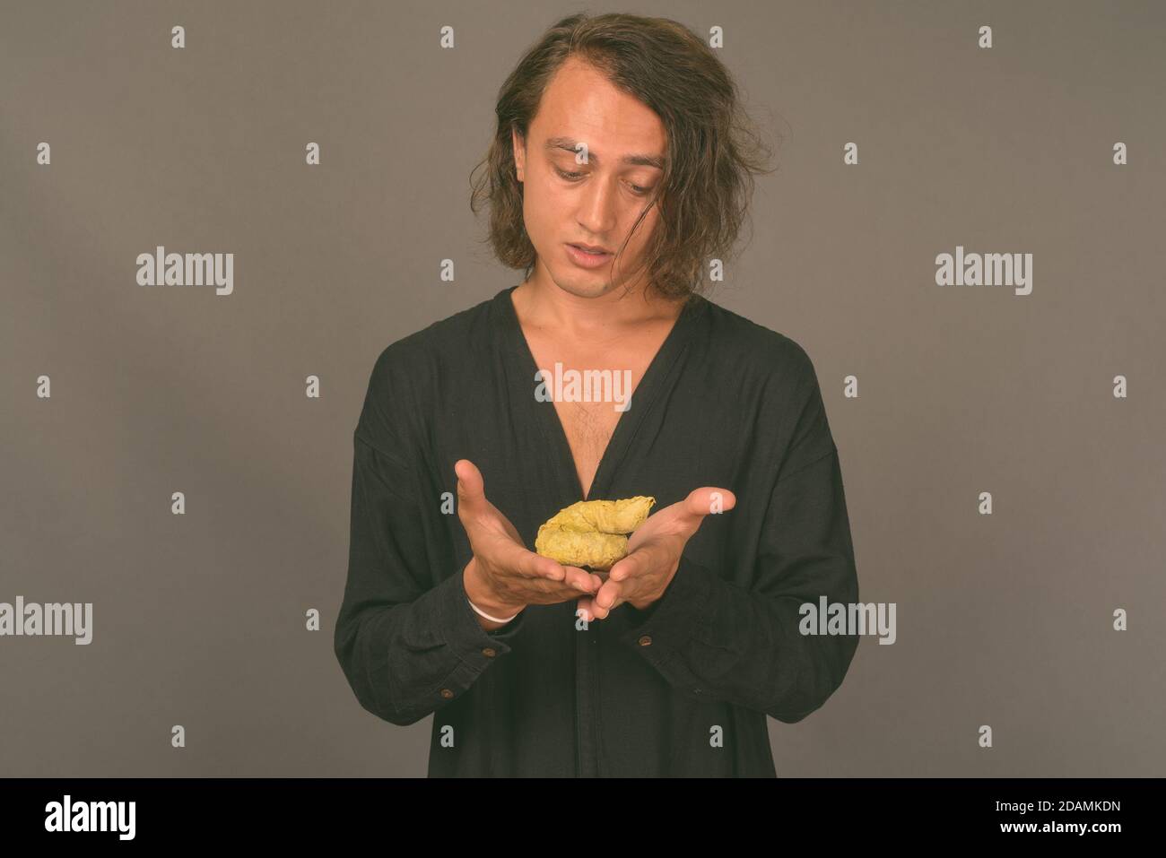 Porträt der jungen gutaussehenden Mann gegen grauer Hintergrund Stockfoto