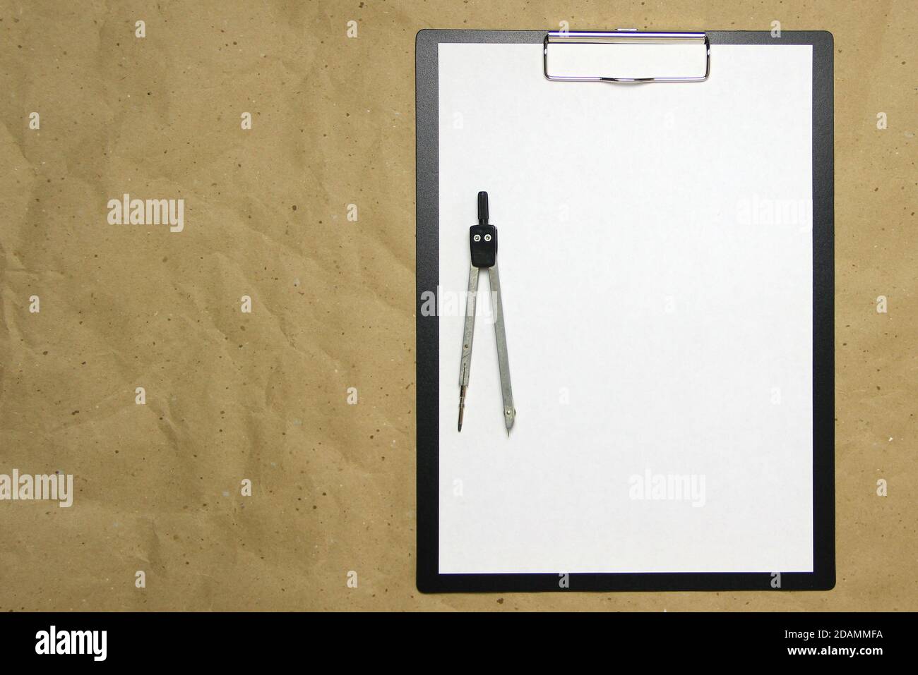 Ein Tablett mit einem weißen Blatt A4-Format mit Trennwand auf beigem Bastelpapier. Konzept der genauen Messungen, Studium und Konstruktion. Stock Foto mit leerem Platz für Ihren Text und Design. Stockfoto