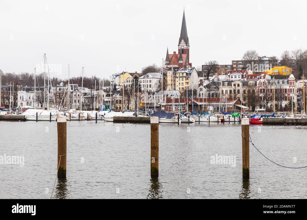 Flensburg Blick am Wintertag, Deutschland. Küstenlandschaft mit hölzernen Anlegestellen Säulen im Wasser stehen Stockfoto
