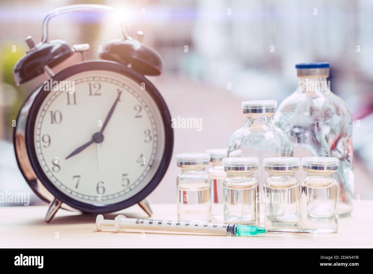 Zeituhr mit Medikamentenflaschen für Zeiten zur Gesundheitsversorgung oder Impfstoffplan Konzept. Stockfoto