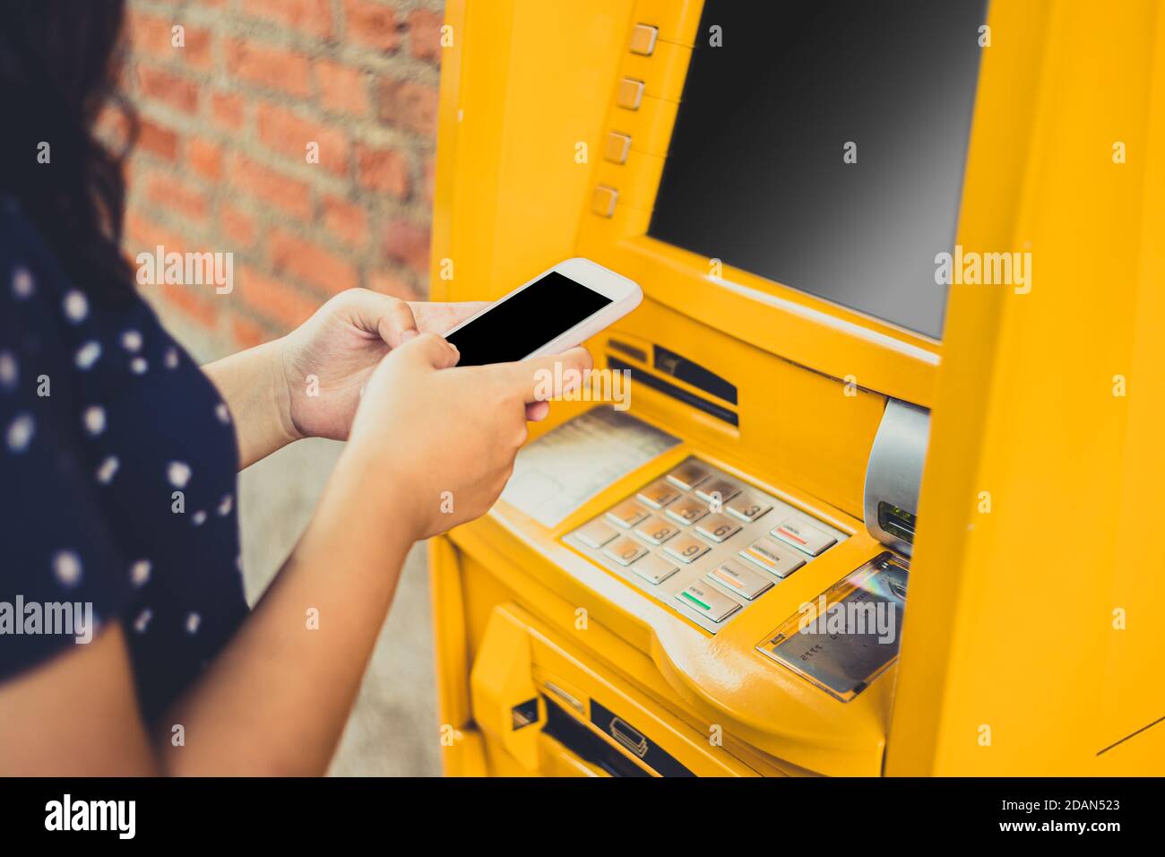 Menschen mit Handy bestellen Geld abheben über Geldautomaten statt Geldautomaten Karte. Stockfoto