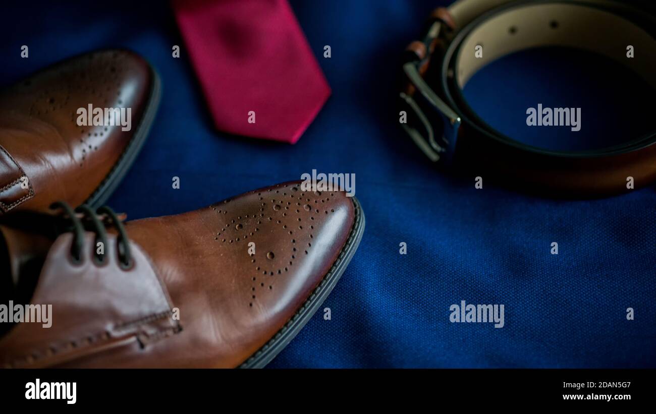 Nahaufnahme der männlichen Hochzeit Bräutigam Accessoires Set.Mode-Stil Braune Lederschuhe und Gürtel und Krawatte blauen Marine Anzug Stockfoto
