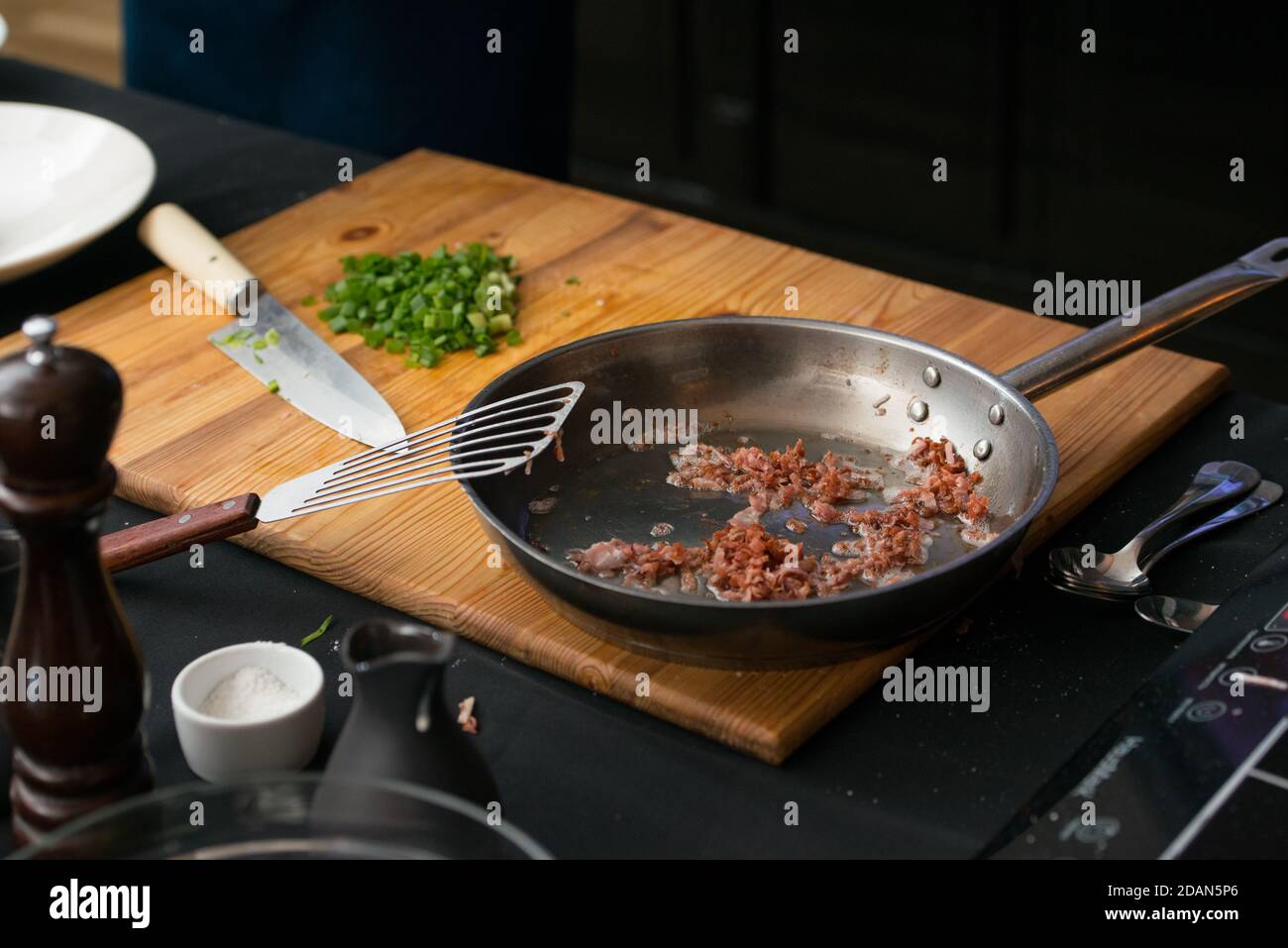 Speck in einer Pfanne auf einem Holzbrett Stockfoto