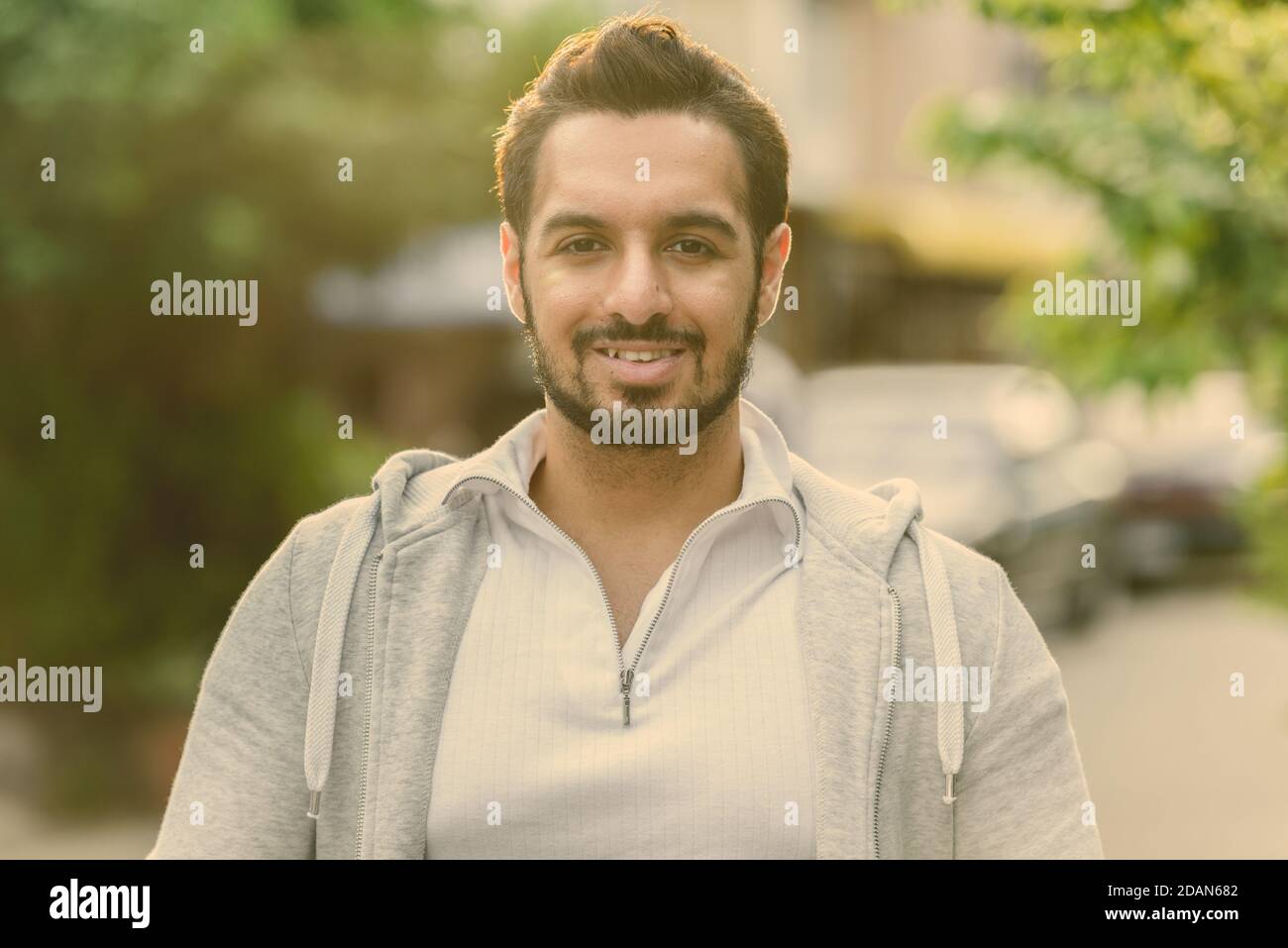 Glückliche junge Aussehenden bärtigen indischen Mann lächelnd im Freien Stockfoto