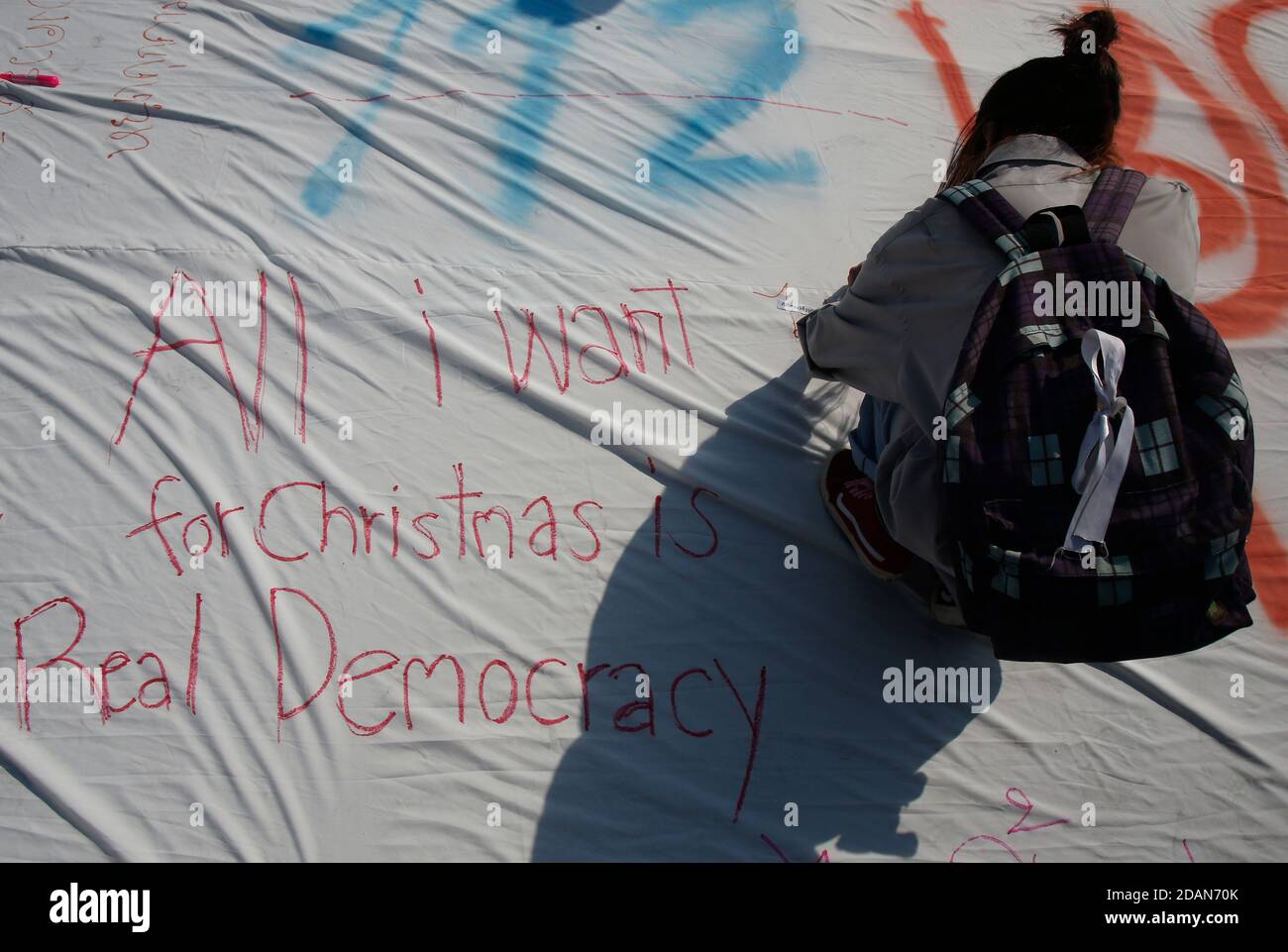 Bangkok, Thailand. November 2020. Ein prodemokratischer Protestierender schreibt während der Demonstration auf einem großen weißen Blatt vor dem Boden: Tausende von prodemokratischen Demonstranten gingen auf die Straße zum Democracy Monument und forderten den Rücktritt des thailändischen Premierministers und die Reform der Monarchie. Kredit: SOPA Images Limited/Alamy Live Nachrichten Stockfoto