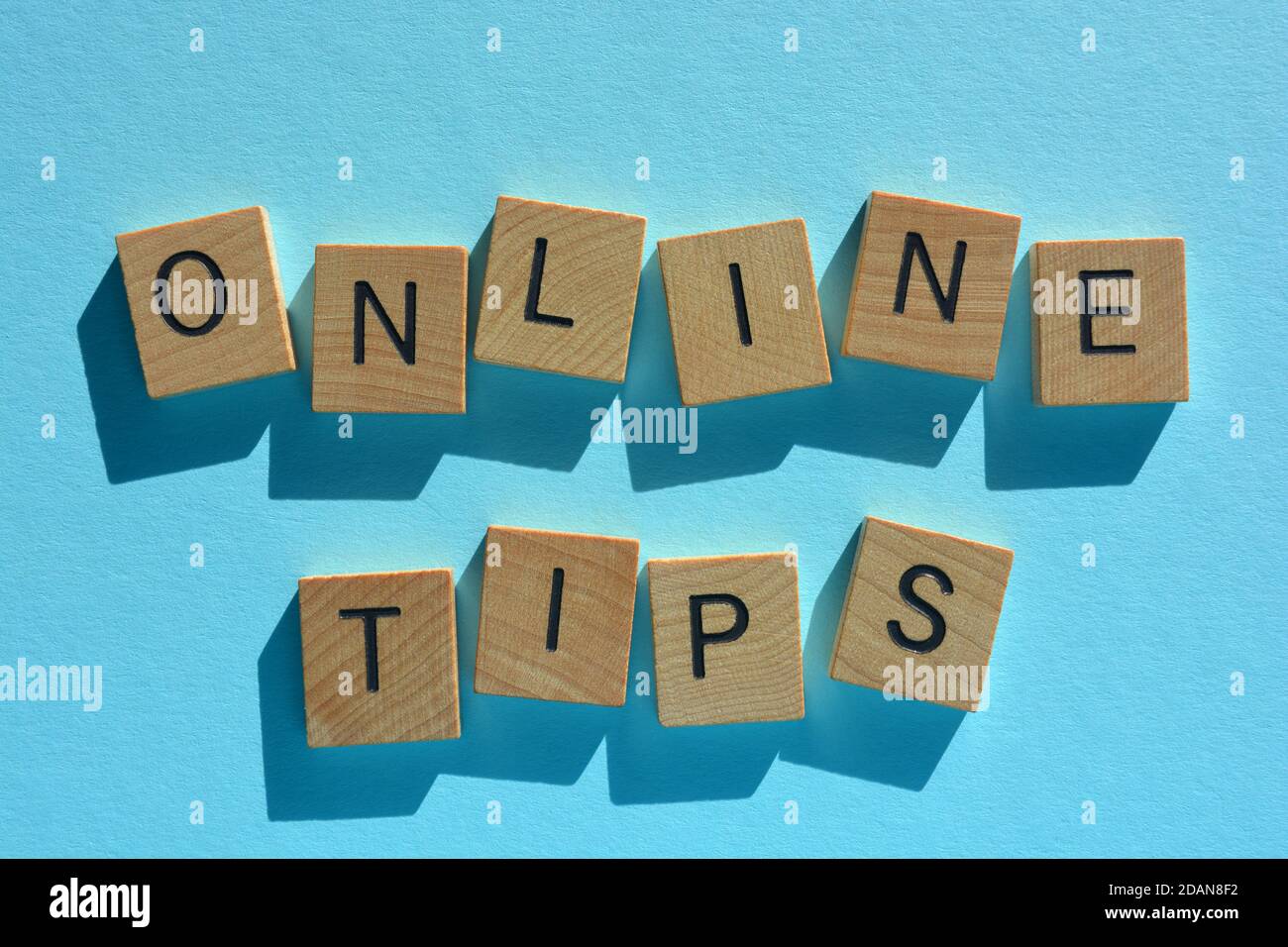 Online-Tipps, Wörter in hölzernen Buchstaben auf blauem Hintergrund isoliert Stockfoto