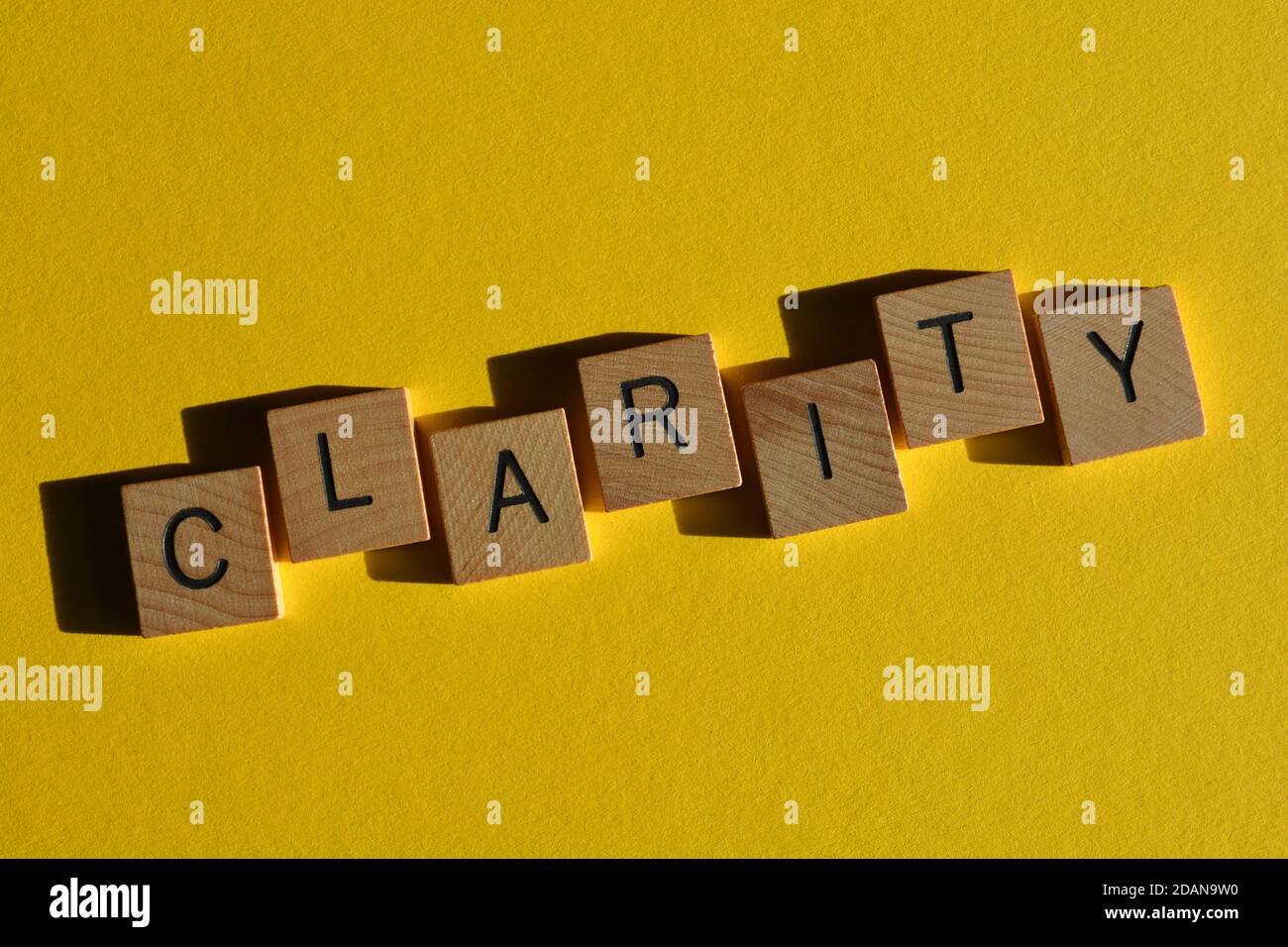 Klarheit, Wort in Holz Alphabet Buchstaben isoliert auf hellgelben Hintergrund Stockfoto