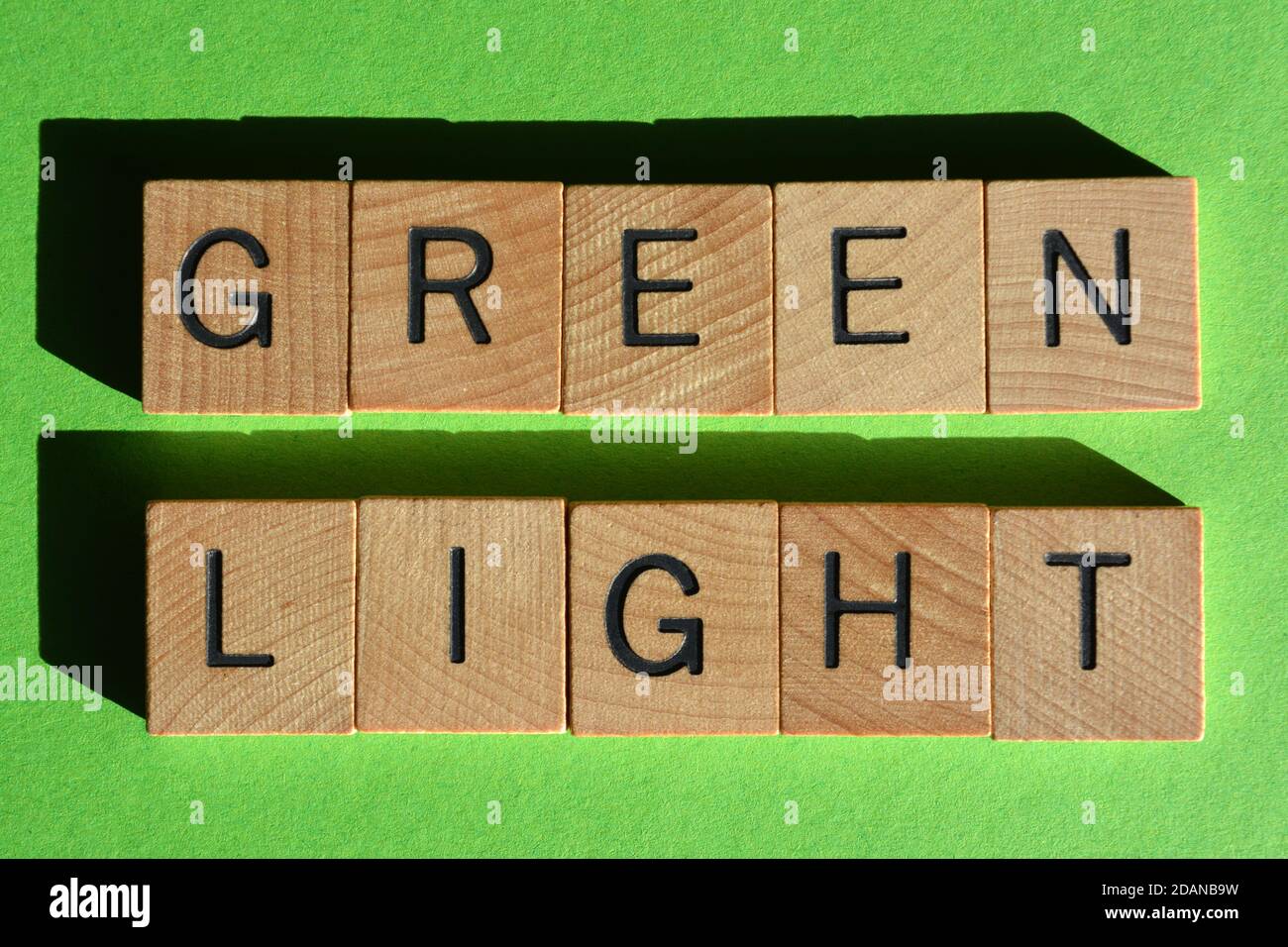 Grünes Licht, Wörter in Holzbuchstaben isoliert auf grünem Hintergrund Stockfoto