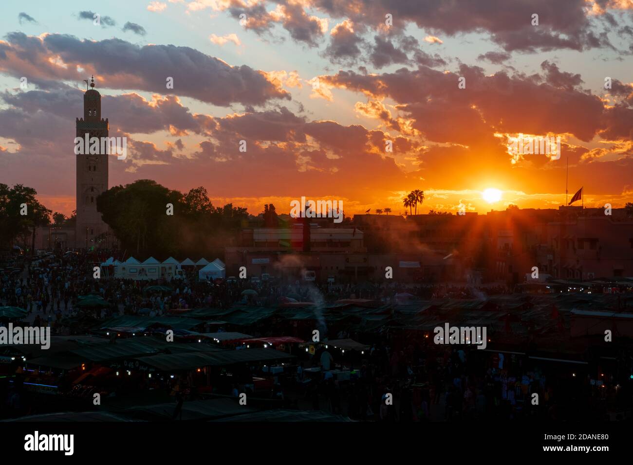 Yamaa el Fna Platz mit seinen Märkten und Menschenmassen und der Turm der Moschee im Hintergrund, bei Sonnenuntergang. Reisekonzept. Marrakesch, Marokko Stockfoto