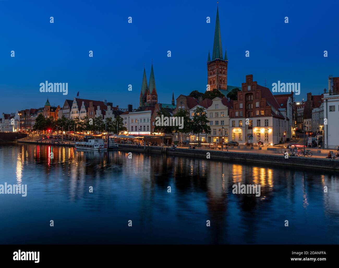 Lübecker Altstadt bei Dämmerung. Die Kirche mit zwei Türmen ist Marienkirche - St. Mary's Church, St. Petri Kirche - St. Peter's hat einen einzigen Turm. Stockfoto