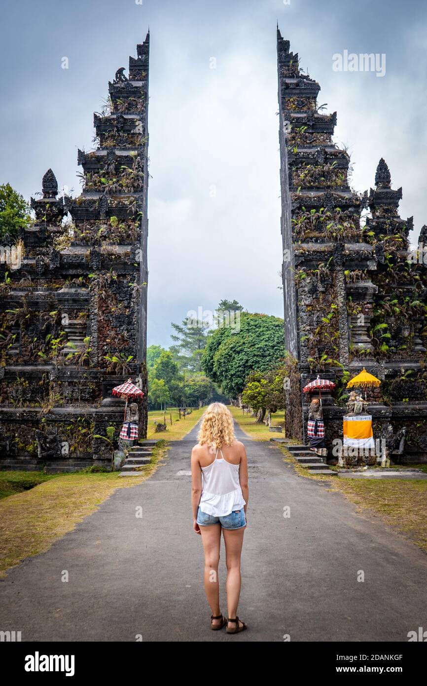 Junge Frau, die vor dem buddhistischen Tor steht Stockfoto