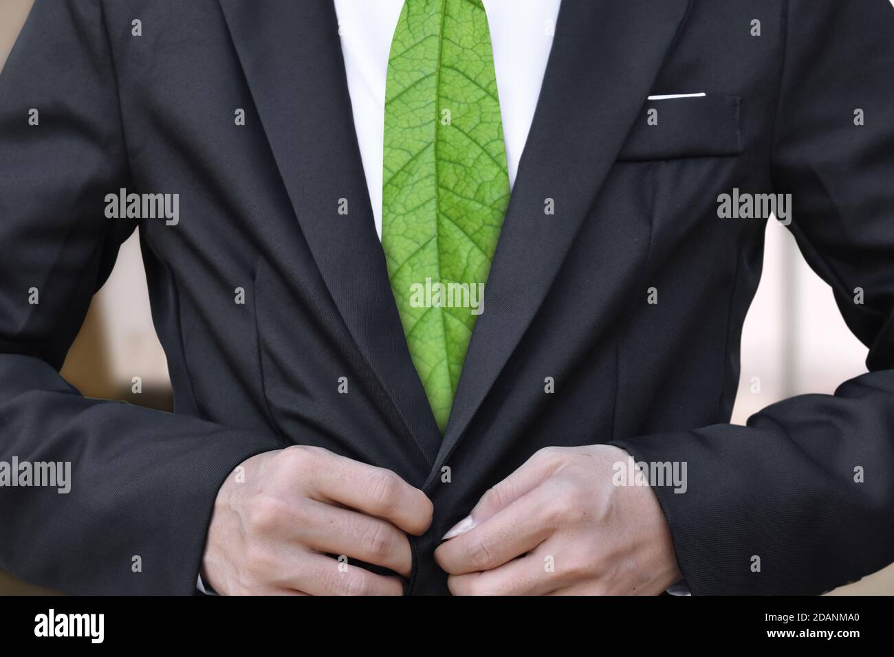 Geschäftsmann im Anzug mit grünem Blatt als Krawatte. Konzept zum Speichern der Umgebung. Stockfoto