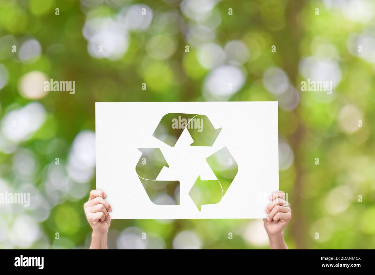 Hand halten Whiteboard mit Recycling-Logo auf grünem Natur-Hintergrund. Earth Day Konzept Stockfoto