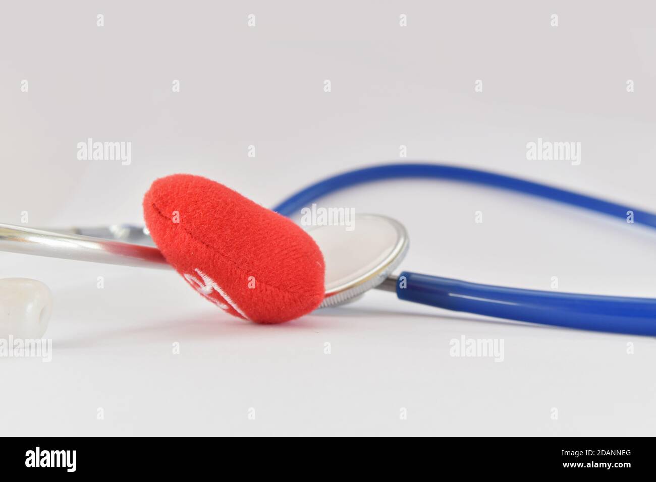 Blaues Stethoskop medizinisch und rotes Herz auf weißem Hintergrund. Idee für Arzt diagnostische Krankheit. Stockfoto