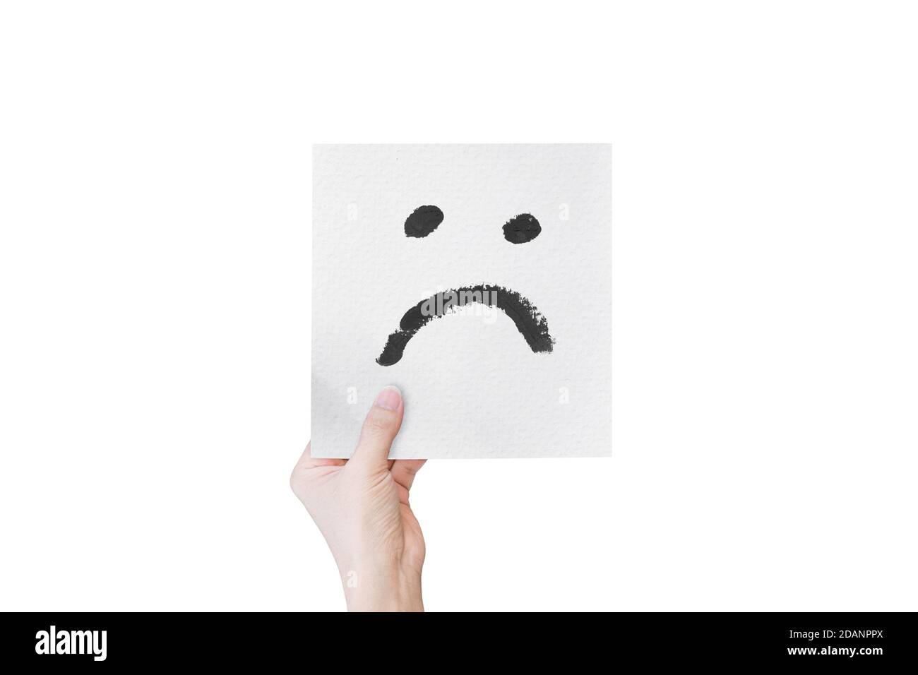 Hand hält weißes Papier mit Hand gezeichnet unglücklich Gesicht Emoticons isoliert auf weißem Hintergrund. Mit Clipping-Pfad. Stockfoto