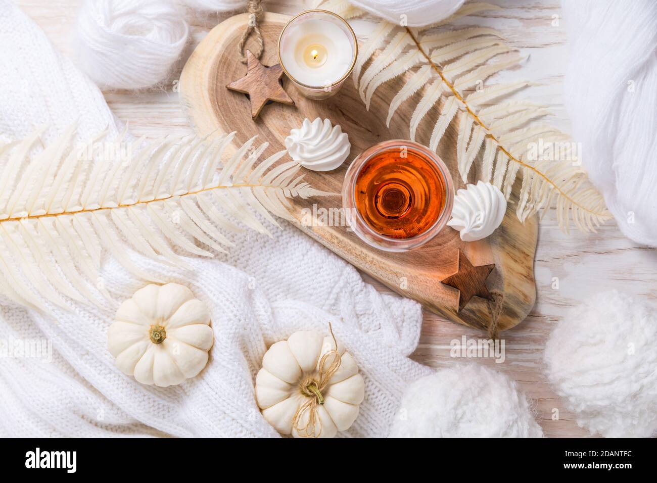 Gemütliches Stillleben für Winter und Herbst mit einem Glas Roséwein, Kürbiskekse, Wolle und warmem Pullover Stockfoto
