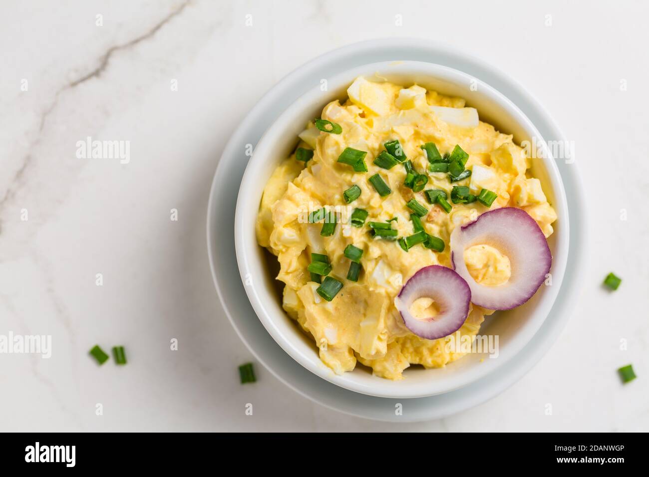 Eieraufstrich mit Zwiebel und Schnittlauch auf Marmorboden Stockfoto