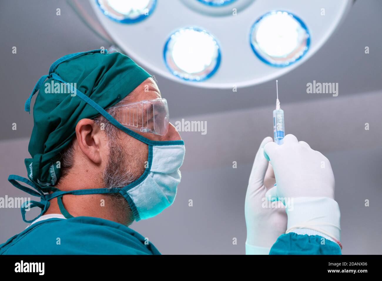 Professioneller Arzt hält Vollnarkose Medizin oder antivirale Arzneimittel Impfstoffnadel Spritze für den Patienten vor der Operation im Operationssaal bei t Stockfoto