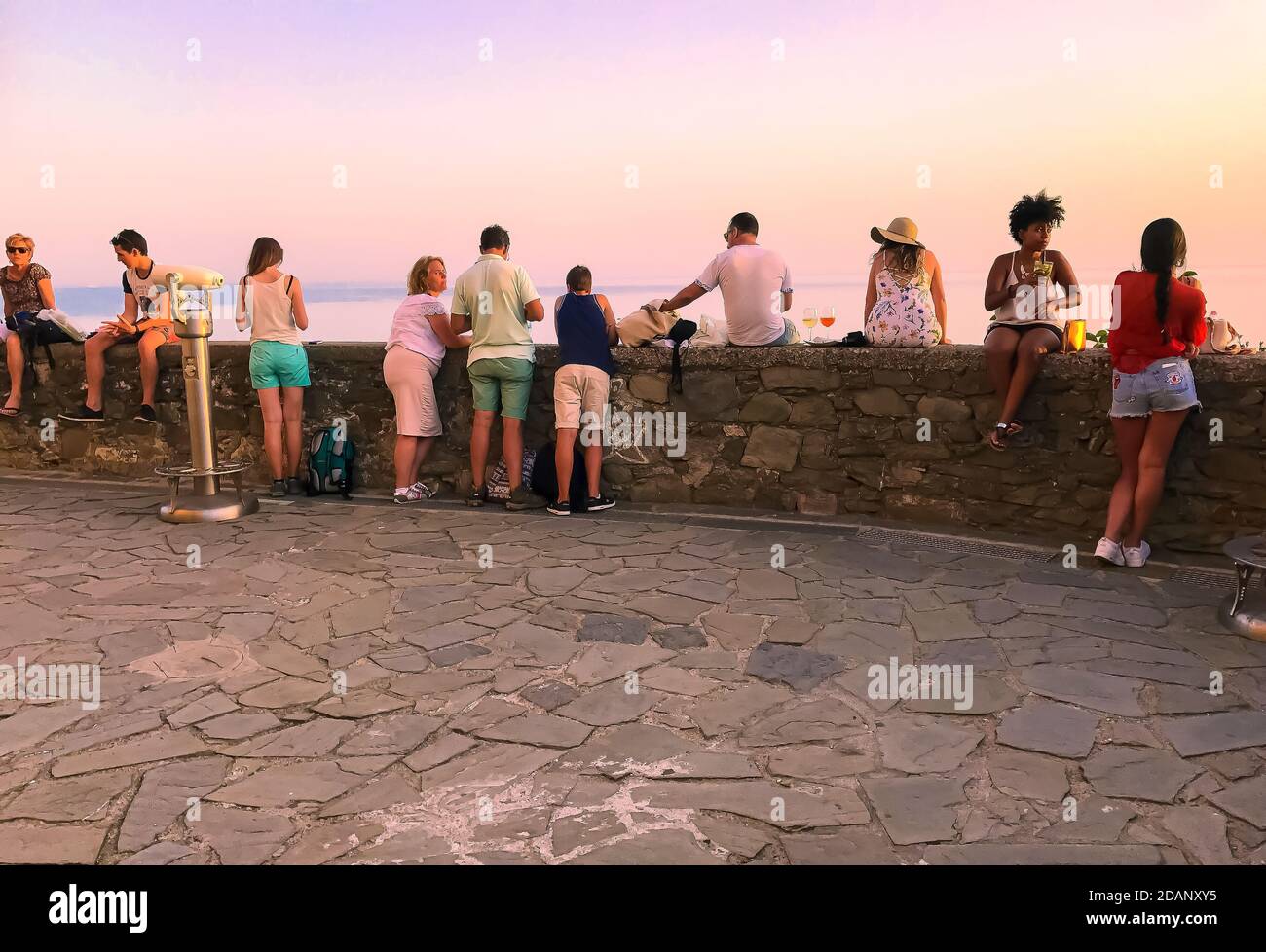 Gruppe von Freunden und Familien genießen Happy Hour und die Meerblick von einer kleinen Mauer Stockfoto