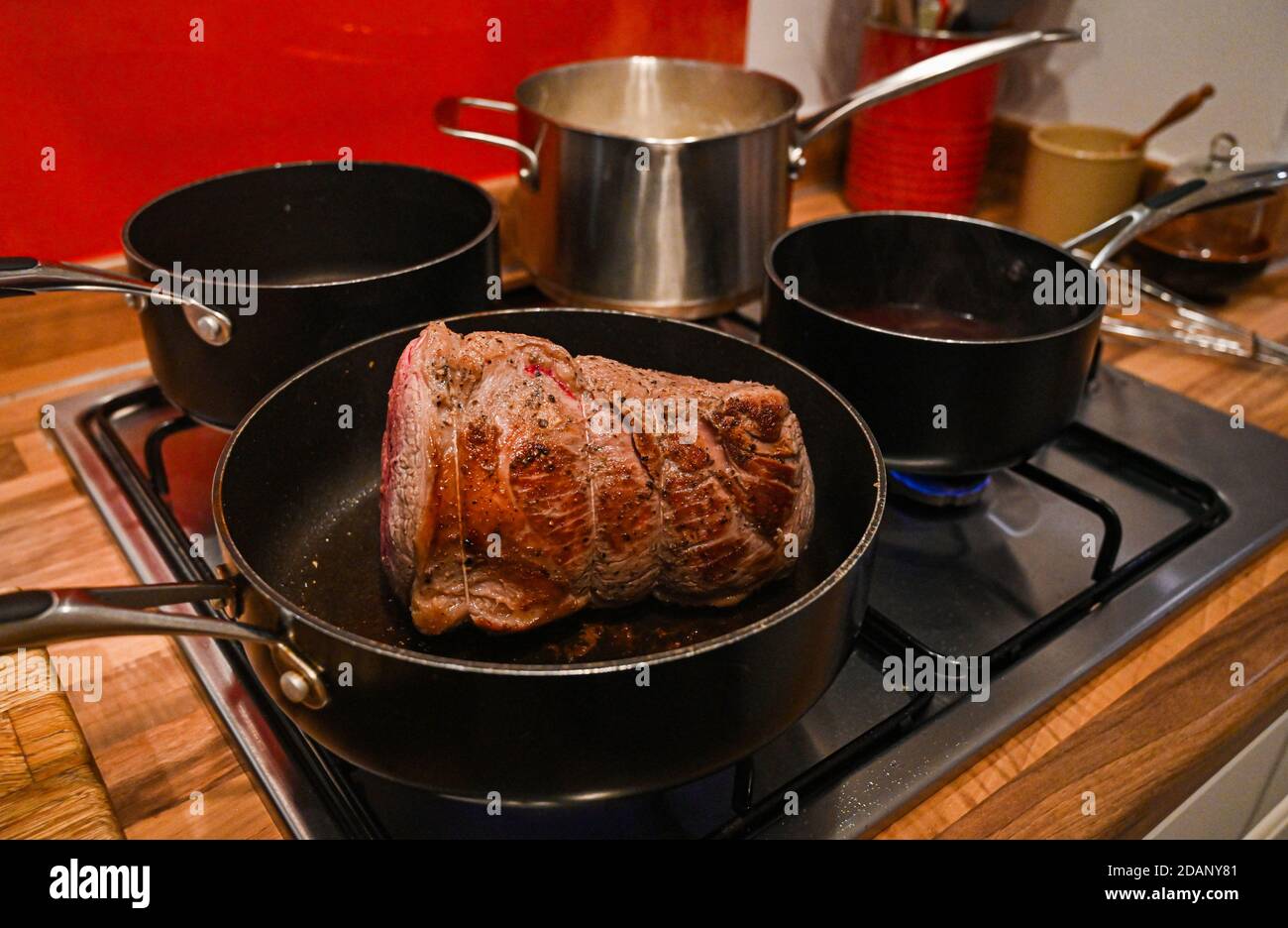 Roastbeef gemeinsame Hausmannskost für Sonntag Mittagessen Großbritannien - Das Rindfleisch in der Pfanne anbraten, bevor es in den Ofen gegeben wird Foto aufgenommen von Simon Dack Stockfoto