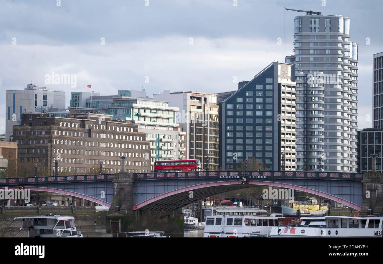 Blick über die Themse von den Victoria Tower Gardens London, Vauxhall Bridge mit roten Londoner Bus- und Bürogebäuden Stockfoto