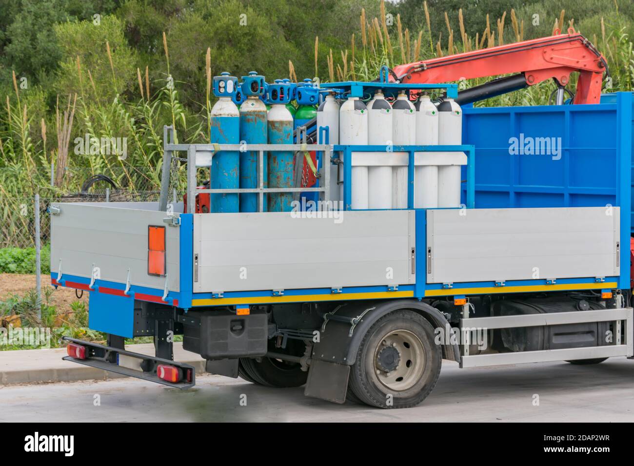 LKW mit Sauerstoffflaschen und medizinischen Gasen zur Versorgung von Krankenhäusern, mit einer orangen Plakette von Gefahrgütern. Stockfoto