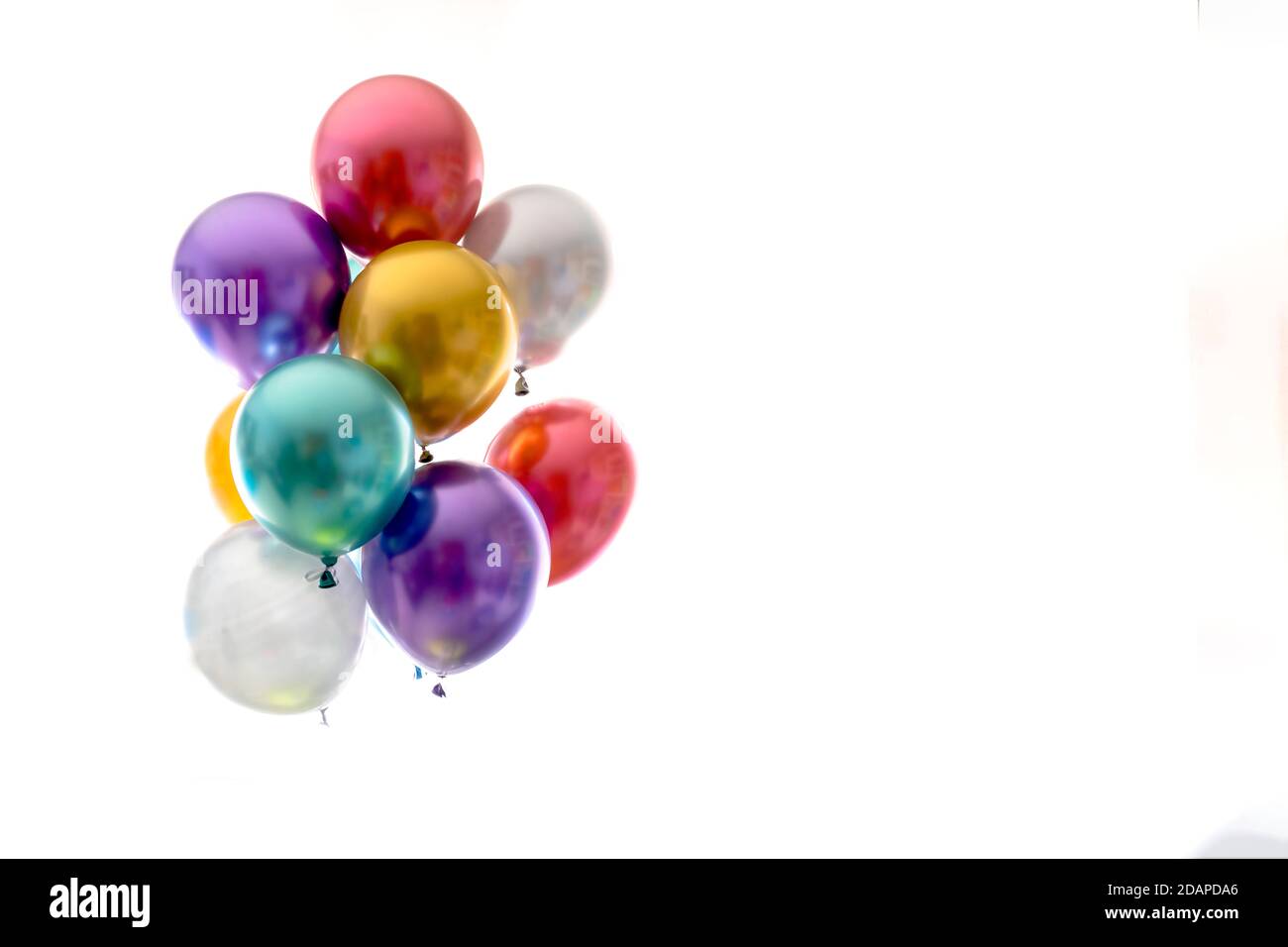 Heliumballons in Metallic-Farben auf weißem Hintergrund Stockfoto
