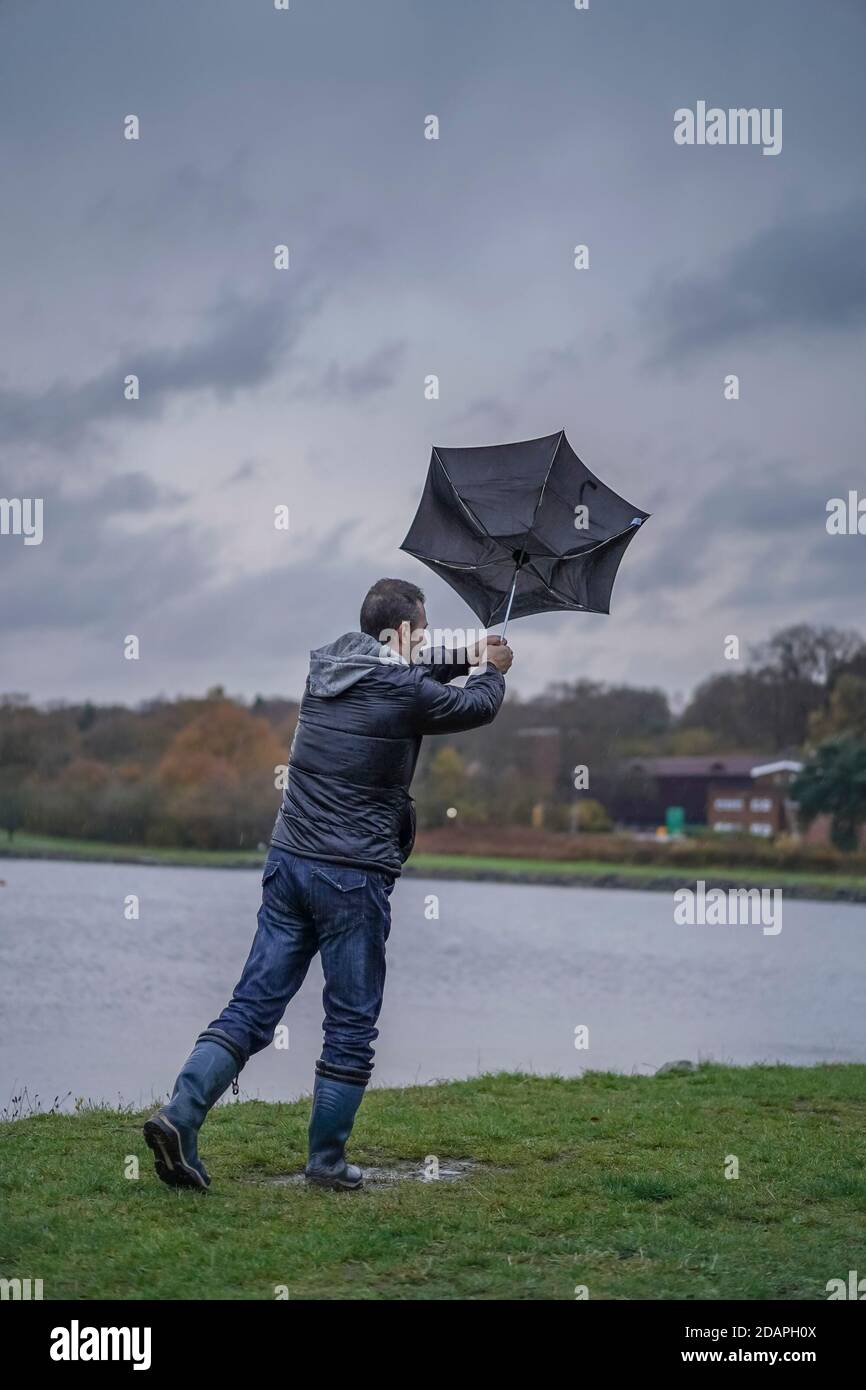 Kidderminster, Großbritannien. November 2020. Wetter in Großbritannien: Sehr nasser und windiger Wind weht die Wanderer am Trimpley Stausee weg. Die Menschen kämpfen darum, ihre Schirme nicht von innen nach außen zu drehen. Kredit: Lee Hudson/Alamy Live Nachrichten Stockfoto