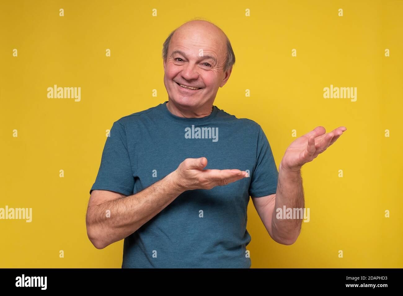 Selbstbewusster hispanischer Senior lächelnder Mann zeigen beiseite Stockfoto