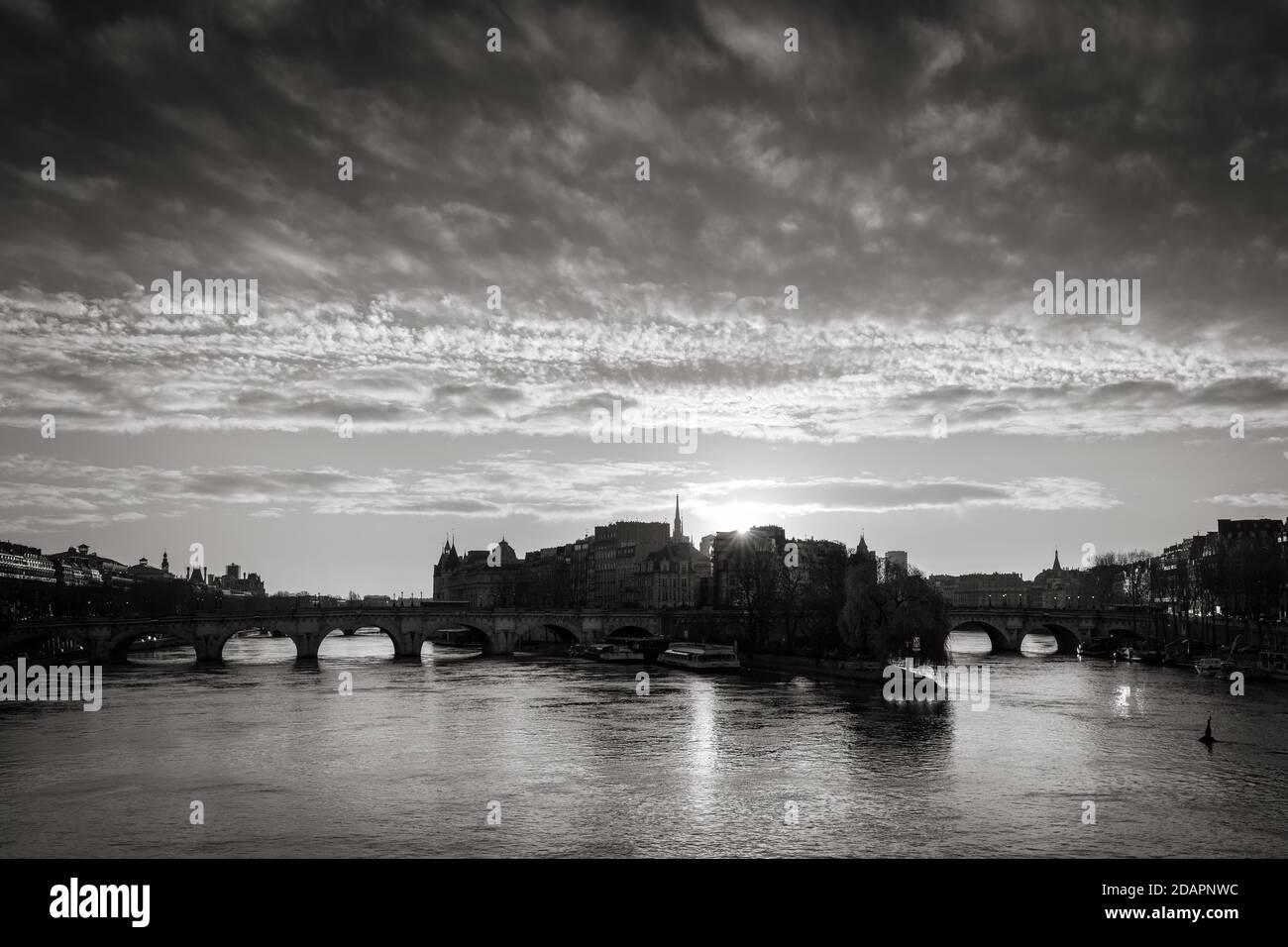 Pariser Sonnenaufgang über der Ile de la Cite und dem Ufer der seine (UNESCO-Weltkulturerbe) mit Pont Neuf in Schwarz-Weiß. Frankreich Stockfoto