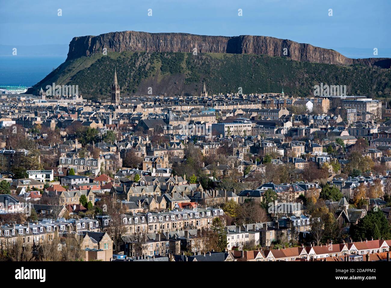 Wohnhäuser in Süd-Edinburgh mit Salisbury Crags im Hintergrund, aufgenommen aus Blackford Hill, Edinburgh, Schottland, Großbritannien. Stockfoto