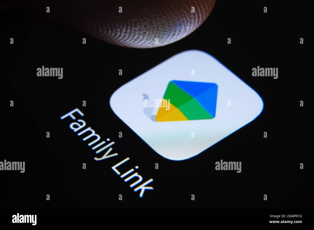 Stafford / Vereinigtes Königreich - November 12 2020: Google Family Link App für Eltern und verschwommene Fingerspitze darüber bereit, den Bildschirm des Smartphones drücken Stockfoto