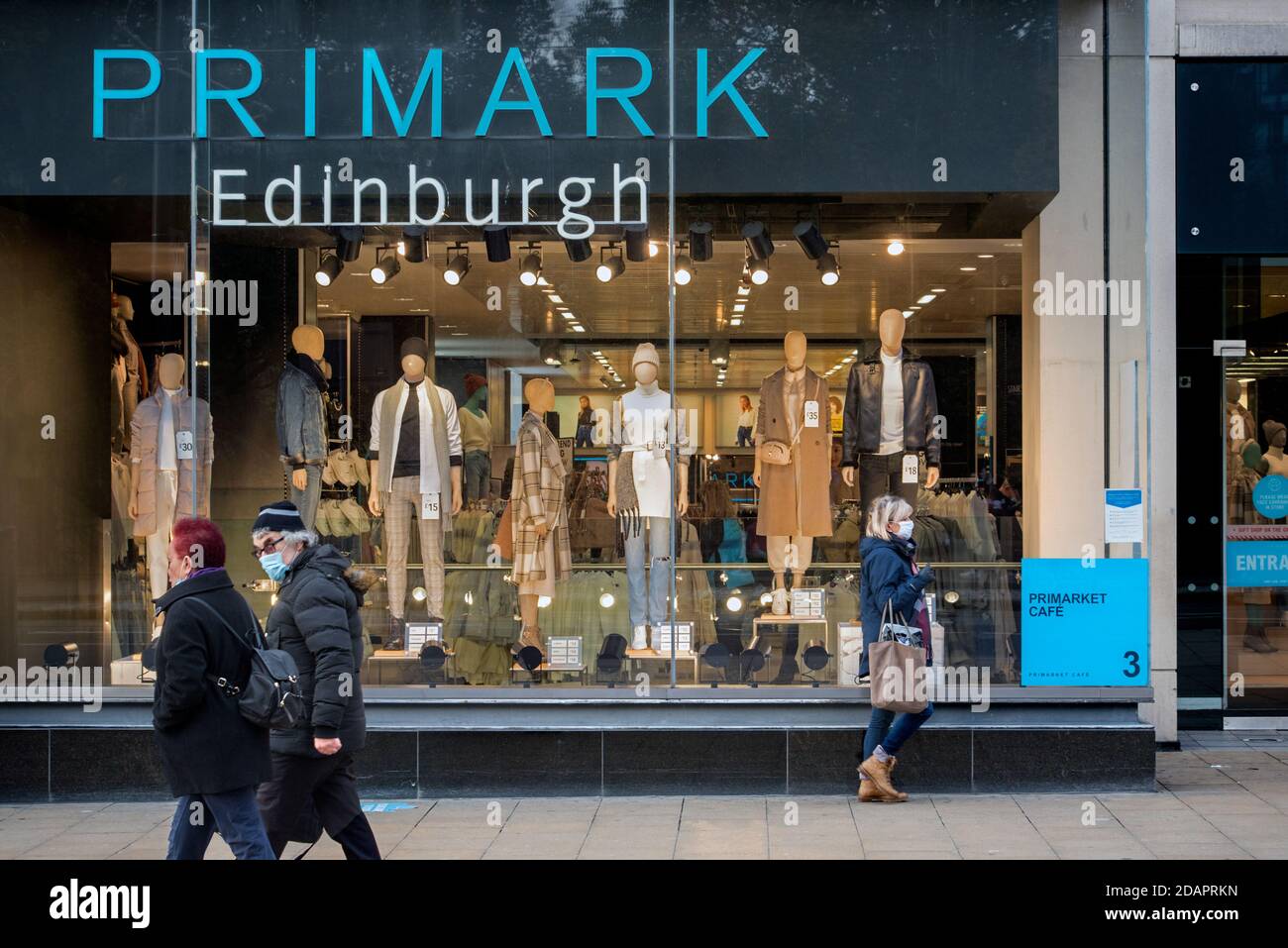 Frau mit Gesichtsmaske während der Coronavirus-Pandemie vor dem Primark Store in der Prince Street, Edinburgh, Schottland, Großbritannien. Stockfoto