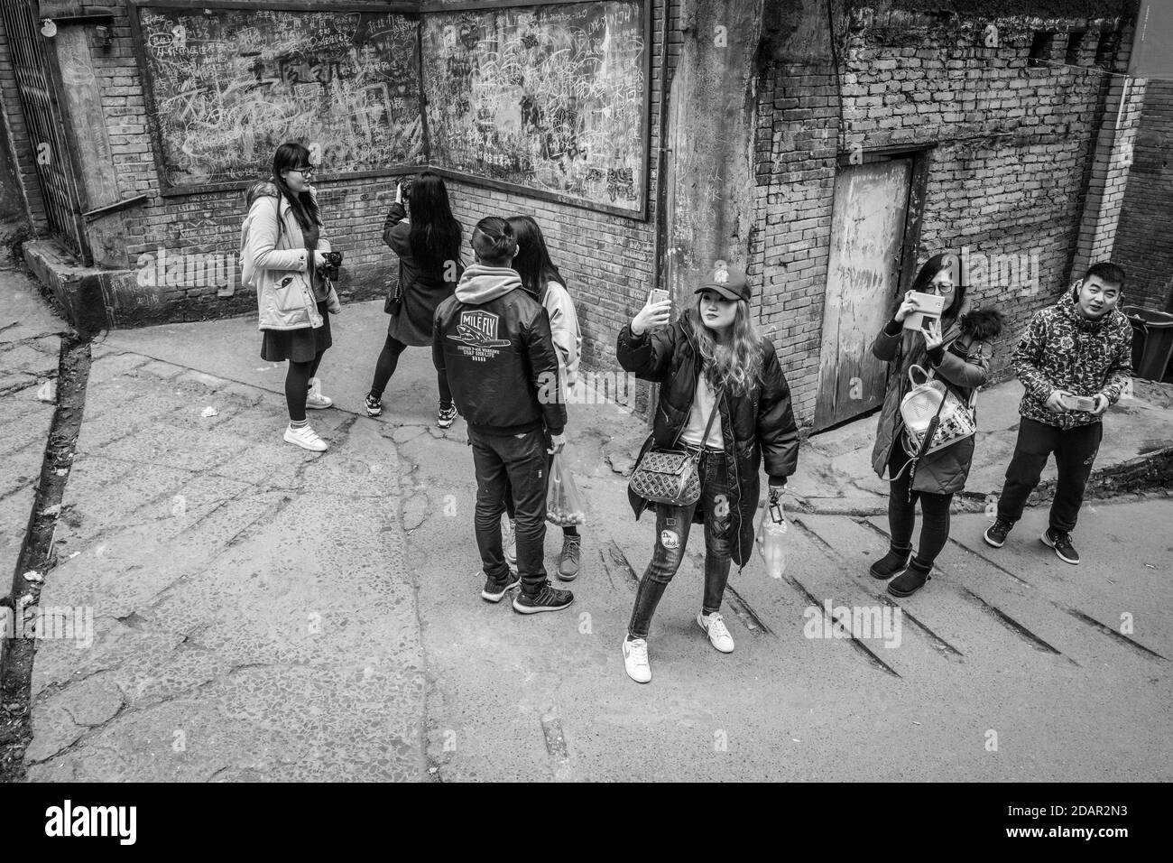 Straßenszene in einer Altstadt von Chongqing. Die Schüler fotografieren Szenen aus einer beliebten Fernsehserie. Diese Viertel sind allmählich Stockfoto