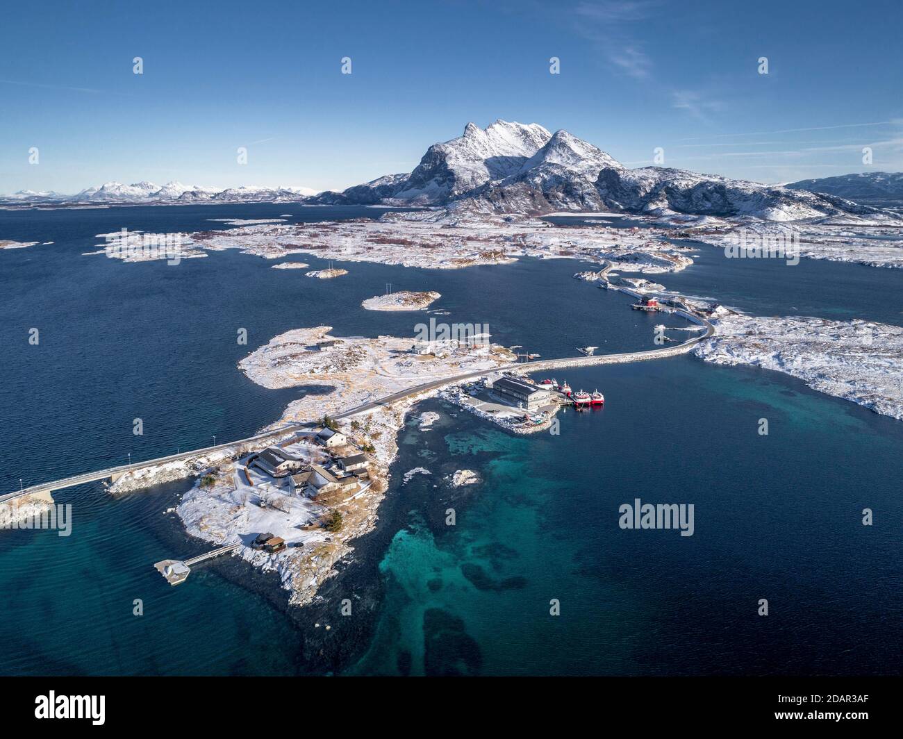 Luftbild, Landstraße durch das Meer verbindet besiedelte, kleine, winterliche Inseln mit dem Festland, hinter Bergen, Heroy, Nordland, Norwegen Stockfoto