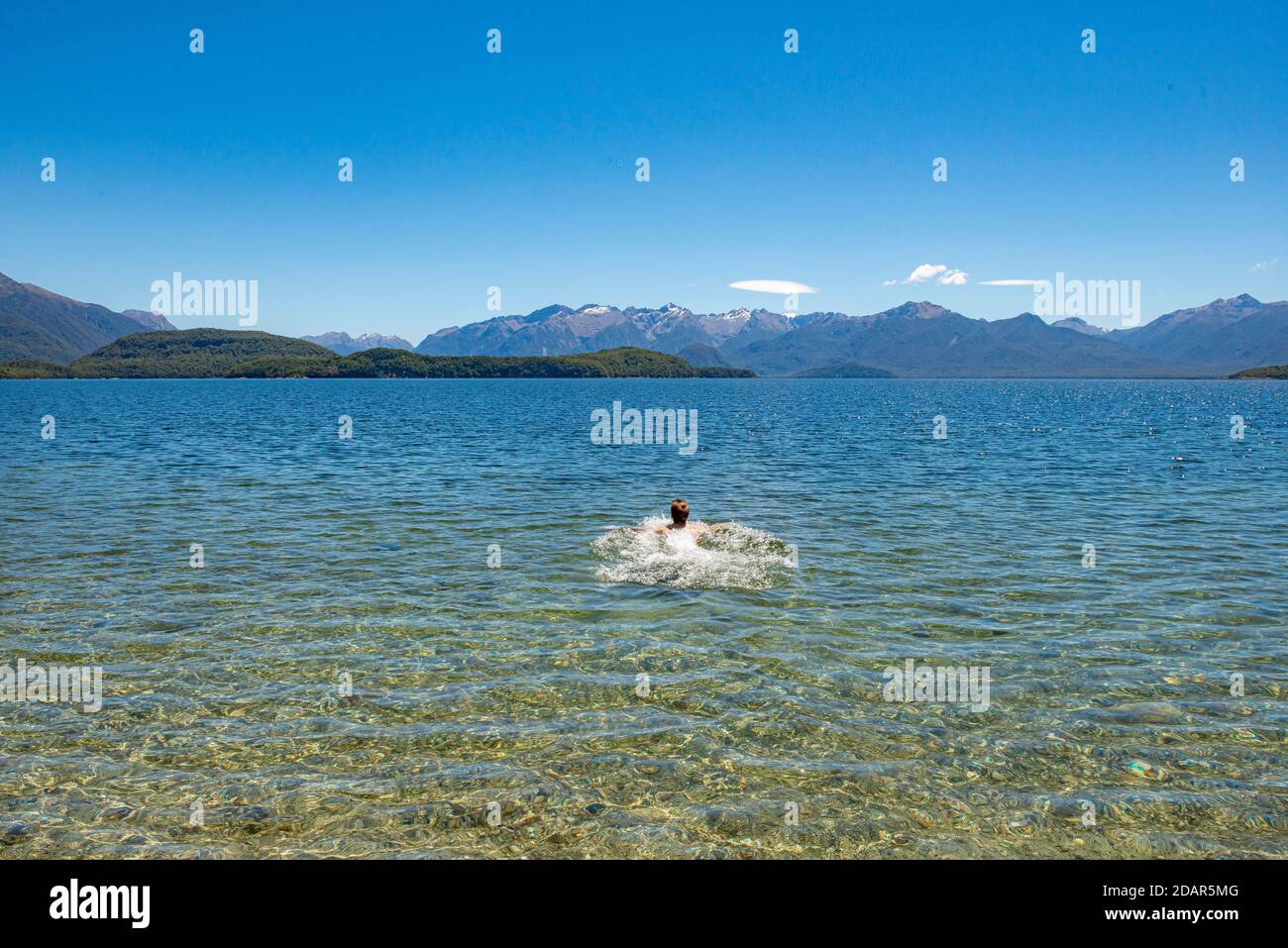 Der junge Mann badet im See, Lake Manapouri, Fraser Beach, Manapouri, South Island, Neuseeland Stockfoto