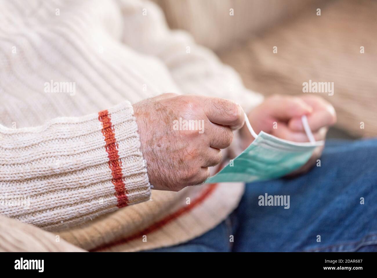Nahaufnahme Ansicht, von Senior Mann Hände setzen Gesichtsmaske gegen Coronavirus . Hochwertige Fotos Stockfoto