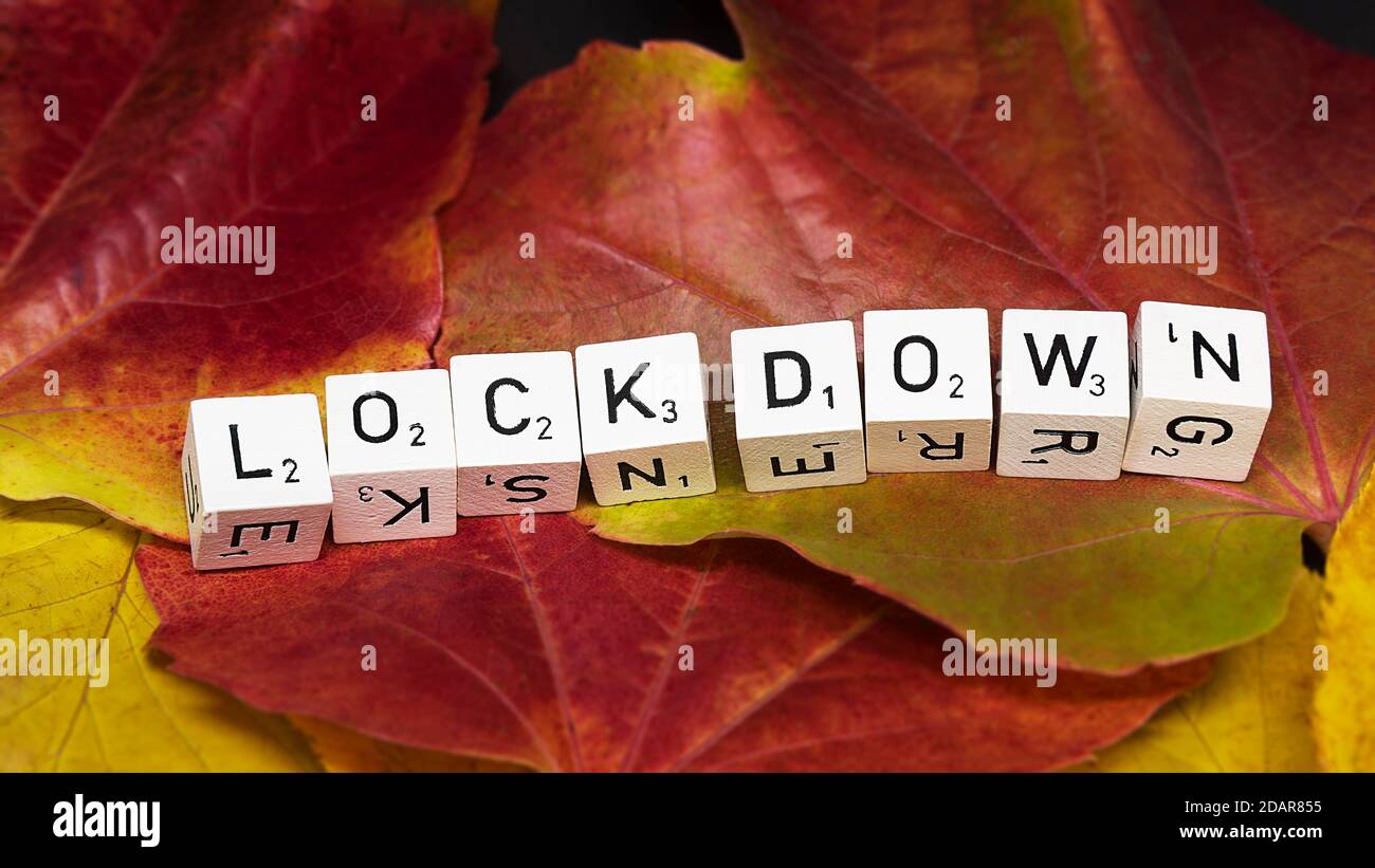 Buchstabenwürfel in einer Reihe, auf Herbstblättern, bilden das Wort Lockdown, Corona-Krise im Herbst, symbolisches Bild, Nordrhein-Westfalen, Deutschland Stockfoto
