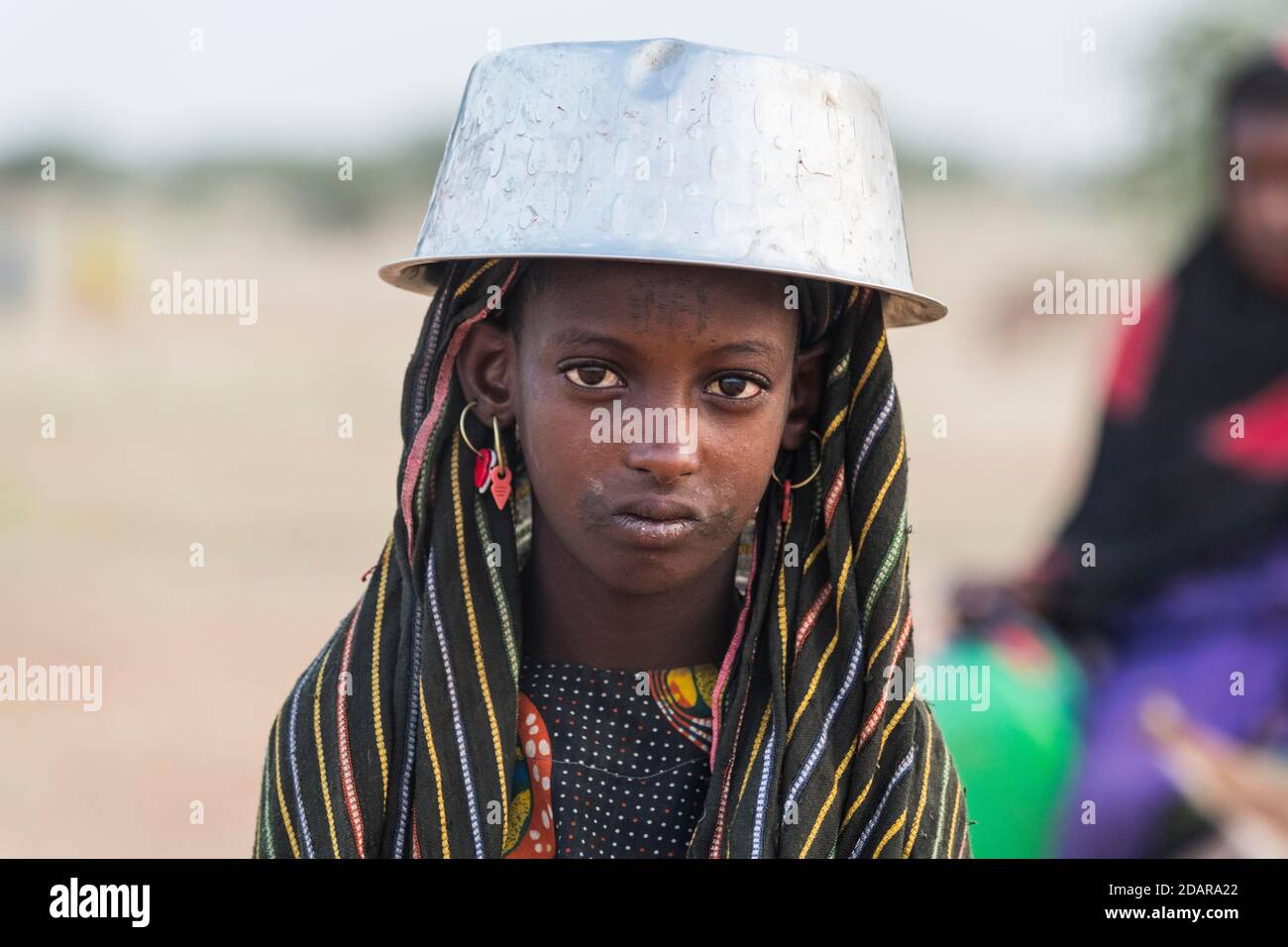 Junges Mädchen mit einem Wassertopf auf dem Kopf, Gerewol-Festival, Balzritualwettbewerb unter den Woodaabe-Fula-Leuten, Niger Stockfoto
