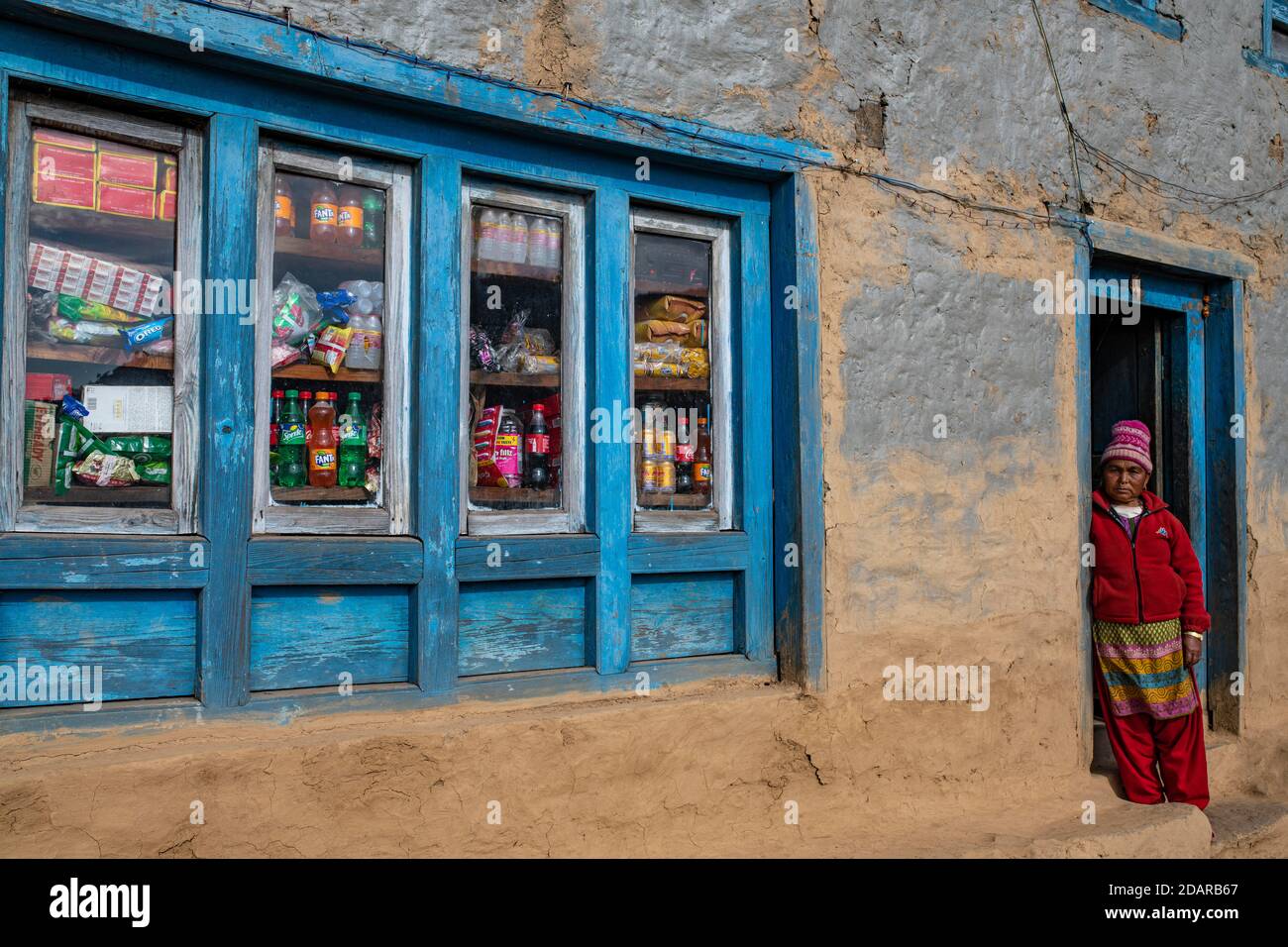 Eine einheimische Frau, die vor der Tür ihres Ladens steht, Himalaya, Solu Khumbu, Everest-Region, Nepal Stockfoto