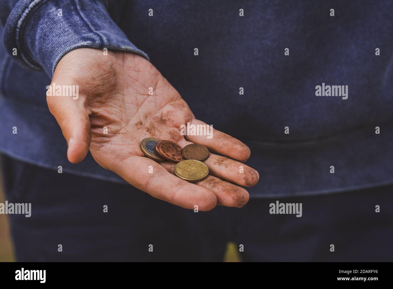 Kein Geld-Konzept. Hand fragt nach Geld. Armer Mann, der um Geld bettelt. Schmutzige Hand mit Euro-Münzen. Stockfoto