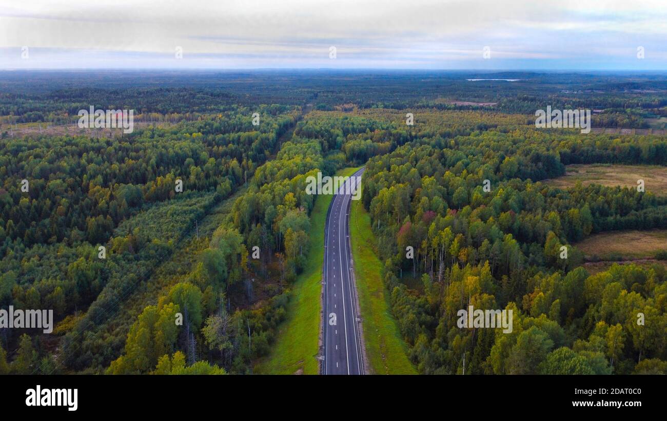 Teil der Autobahn im September. Entlang des Mischwaldes. Mit Blick in den Himmel. Draufsicht Stockfoto