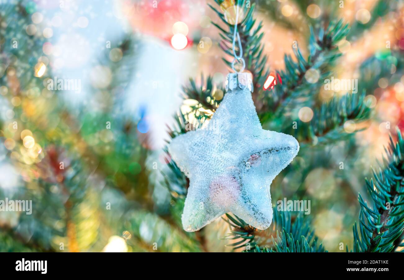 Glitzernder Glasstern auf Tannenzweig. weihnachtsdekoration Stockfoto